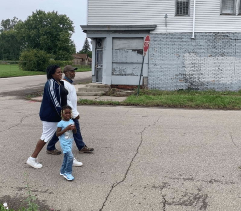 A Detroit family walks down a street with no sidewalks. Source: Joel Kurth/Bridge Michigan.