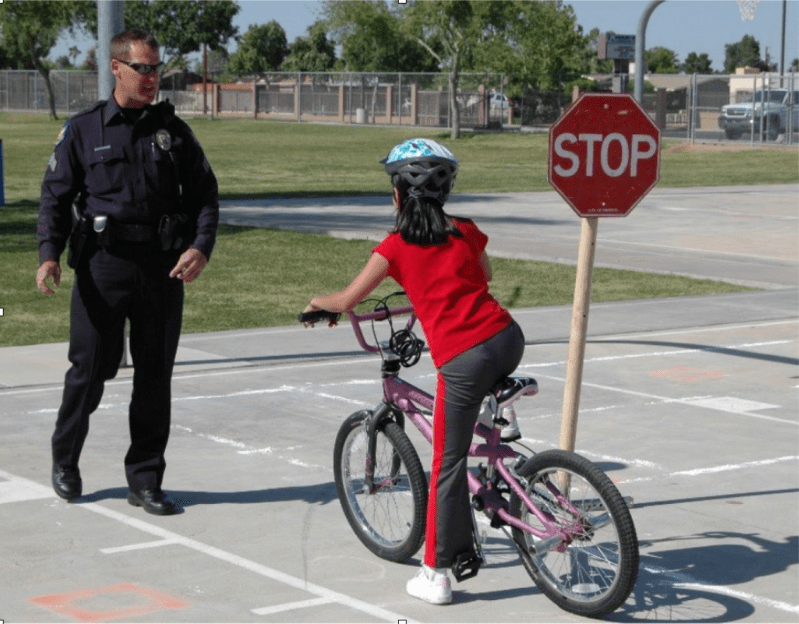 Yes, that *is* an armed law enforcement officer standing mere feet from a child on a bike. Source: NHTSA