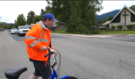 At last year's WeekWithoutDriving, a man in an orange high-vis jacket wheeled a tricycle across a street with no crosswalk. Photo: Disability Rights WA